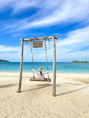 Relaxing on the beach swing in serene Samae San Island, Thailand under a clear sky
