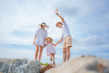 Happy family enjoying vacation on the beach together having fun on summer vacation.