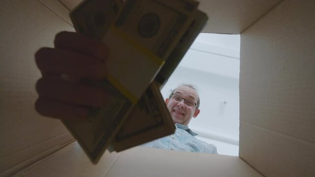 Man putting euros and dollars into a box, displaying focus and careful handling in 4K slow motion 120fps