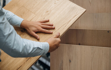 Surface of the parquet. Detailed close up view of man's hand in the hardware store
