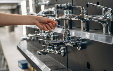 Bathroom tap. Close up view of woman that is in the hardware store