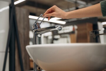 White sink. Close up view of woman that is in the hardware store