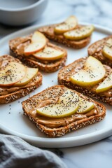 Delicious whole grain toast topped with peanut butter and sliced apples on a white plate during a sunny