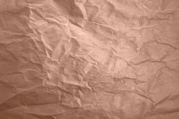 Close-up of the texture of crumpled paper with a glitter effect in the color of the year 2025 Mocha Mousse. Shimmering surface and elegant folds, for design and creative projects.