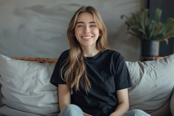 Beautiful young woman looking happy relaxing on the couch wearing a casual black mockup t shirt