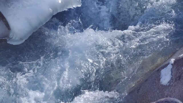  cold mountain river with ice and snoe in Kyrgyzstan