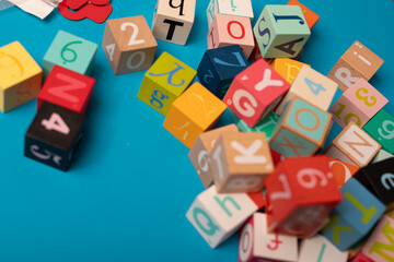 Colorful wooden blocks with letters and numbers scattered on a blue background