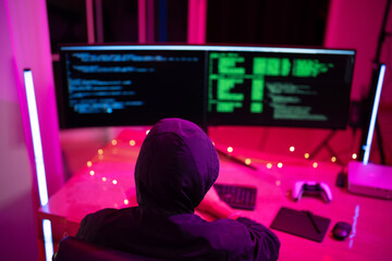 Black Hat Hacker hoodie concept at a laptop computer hacking the Internet. Cyber crime and security principles.