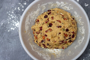 Close up photo of sugar free dough in a bowl. Preparation of dough for cookies with raisins and cranberries, Eating healthy concept. 