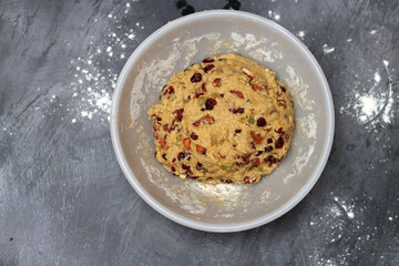 Close up photo of sugar free dough in a bowl. Preparation of dough for cookies with raisins and cranberries, Eating healthy concept. 
