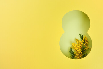 8 March greeting card. Paper cut Eight made of yellow background and fresh spring flowers bouquet of yellow mimosa. Greeting card for Womens Day on March 8 Flat lay top view. International Womens day