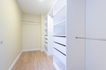Spacious and Modern Walk-In Closet with Open Shelving and Light Flooring. Modern Home Interior
