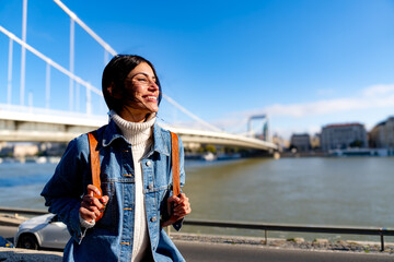 Obraz premium A happy woman enjoying the moment, smiling and looking out at the view on a beautiful, sunny day. Copy space