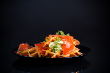 vegetable potato waffles with spread and lightly salted red fish in a plate