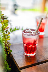 glass of refreshing red sirup cocktail with straw - close up