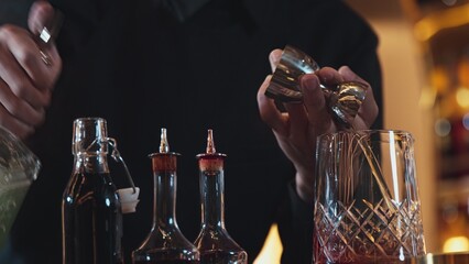 Closeup hand bartender holding jigger to measure liquor sugar into mixing glass ingredients alcohol preparation creative mixed cocktail. Special refresh drink showcasing nightlife mixology. Vinosity.