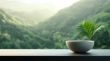 Serene bowl placed on a wooden table overlooking lush green hills at sunrise.