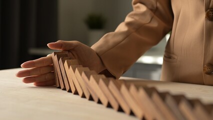 Crisis Management and Risk Assessment in Business Planning An Economic Approach to Financial Strategies with 4K Stock Video of Hand Stopping Wooden Dominoes