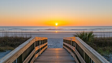 Obraz premium Serene Wooden Boardwalk Leading to Tranquil Ocean at Sunrise Over Sandy Beach