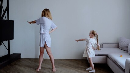 Caucasian family mother and daughter performing workout at home health and fitness. Young adult...