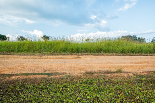 Landscape of gravel road in countryside with blue sky. Road in rainy season. Side view of dirt road on top mountain. road background.