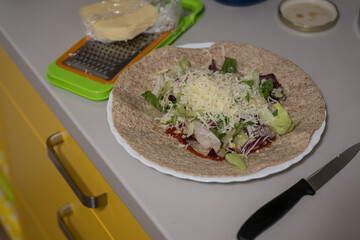 Tortilla with salad and cheese open.
