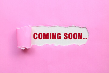 Coming soon message written on ripped torn pink paper. Text COMING SOON
