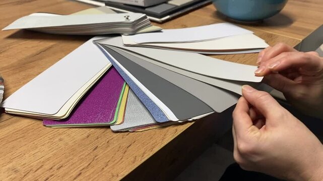 Currently examining various color samples and swatches on a wooden table for an upcoming design project