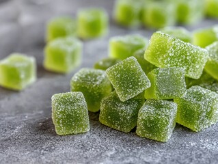 Green gummy candy cubes with sugar coating on a textured background
