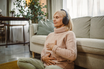 Obraz premium senior woman eyes closed have guided training yoga or meditation