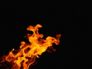 Dynamic fire flames dancing on a dark black background, energy, fiery, burning