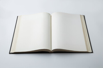 Open empty white paper book laying on white background