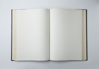 Open empty white paper book laying on white background