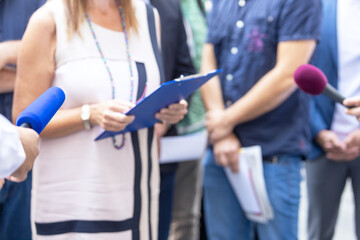 Whistleblower holding confidential document and giving a statement to journalists at press conference or media event