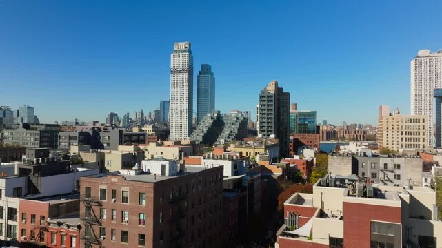 Aerial views capture Brooklyn borough in New York City, dense skyline with iconic Empire State Building prominently rising in Manhattan ib the background