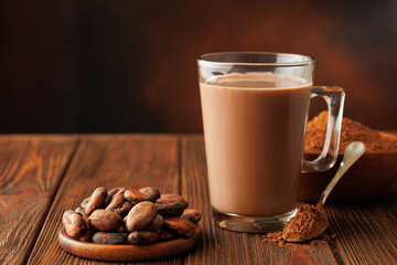hot chocolate in cup and cacao beans with powder on table