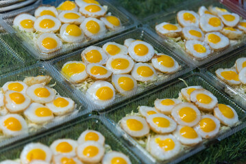 a lot of Quail eggs fried in the tray for sale   