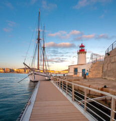 An iddle sailboat and a lighthouse in the old harbor of Ibiza, Balearic Islands, Spain