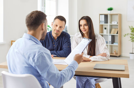 Family receiving consultation from a financial adviser or real estate agent during a meeting in an office. Guidance and support help the family make informed decisions about investments or property.