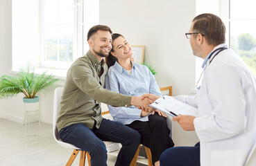 Doctor or psychologist congratulating happy patients, consulting young couple, counseling, family therapy, fertility treatment for infertility care, support therapist helping on medicine meeting