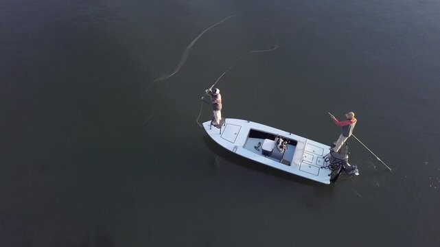 Aerial high angle view of men fly fishing from a small boat.