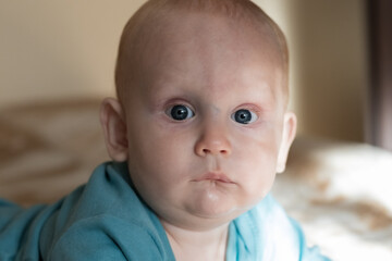 Close-up portrait of a baby, newborn boy, 9 months old, with big blue eyes