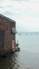 House partially submerged in water, likely due to flooding or rising sea levels. A poignant image of environmental impact and displacement.
