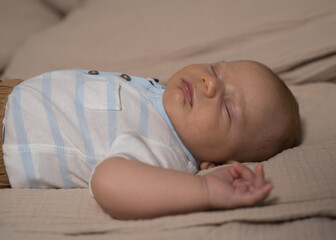 A newborn baby sleeps sweetly in bed.