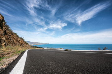 Mediterranean sea coast road into mountains horizon in summer with beautiful bright sun rays