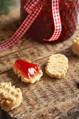 Filling homemade Christmas cookies with strawberry jam