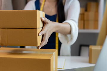 A woman who is running an online clothing business and is also a designer, working on designing...