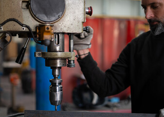 welder working in his industry with a metal drill