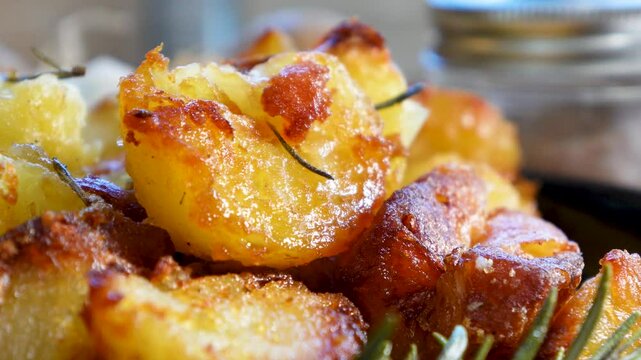 Cooking garlic rosemary roasted potatoes for dinner as a side dish. Baking potatoes with fresh rosemary and garlic made in the oven.