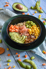 poke bowl with seeds and vegetables, avocado and salmon. homemade recipe fresh ingredients